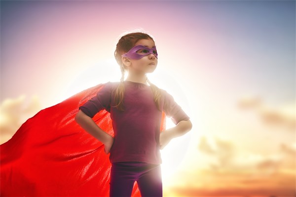 Ein Mädchen, verkleidet als Superheldin. 